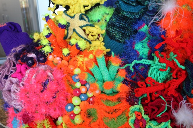 Crocheted work that resembles sea creatures and parts of a coral reef.