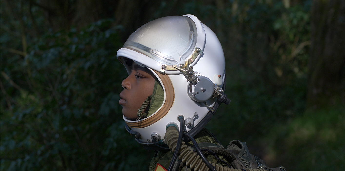 A black person wearing a space helmet.