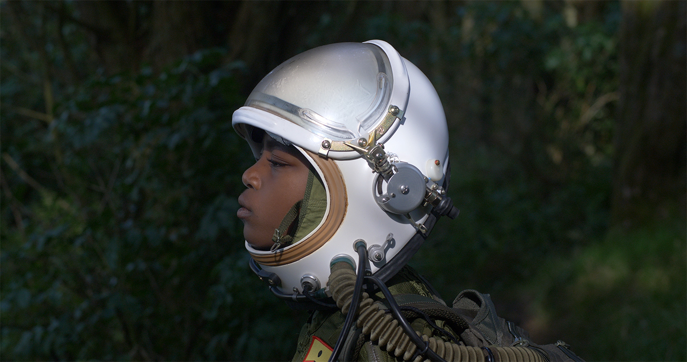 A black person wearing a space helmet.