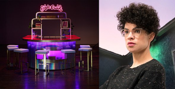 From left to right: A neon-lite table with stools, and a person with curly hair.