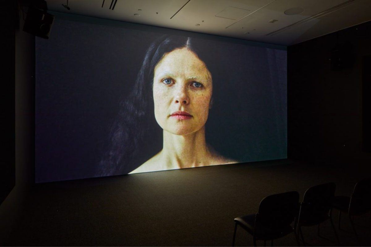 A picture of a woman is projected onto a screen.