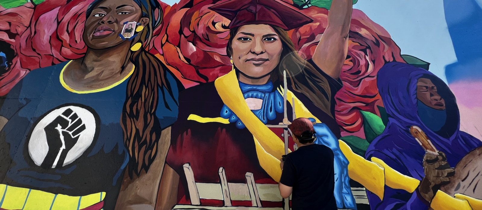 An artist paints a colorful mural.