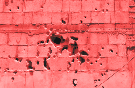 Close up of pink brick wall with bullet holes