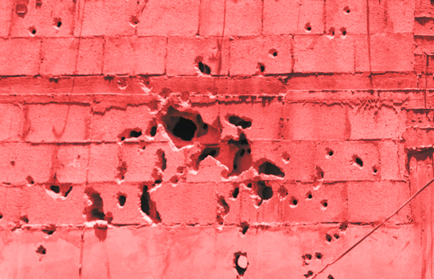Close up of pink brick wall with bullet holes