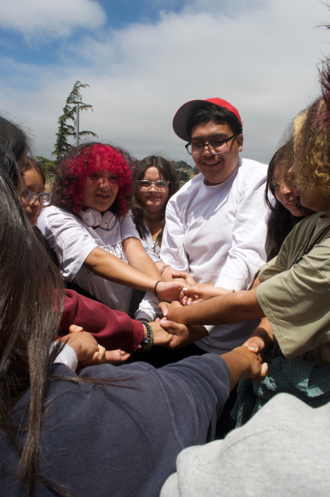 Art for All students doing an ice breaker activity, called human knot, with Barrios Unidos's youth program participants