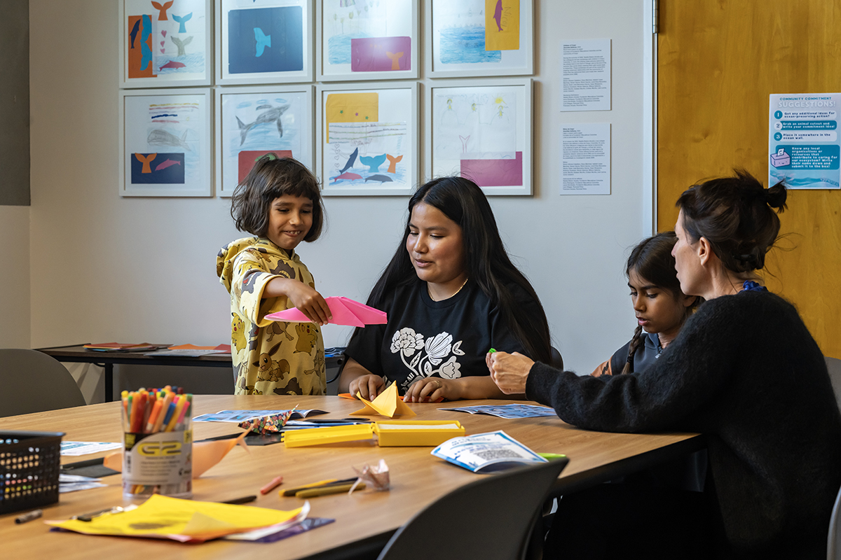 Child works alongside adults at art workshop