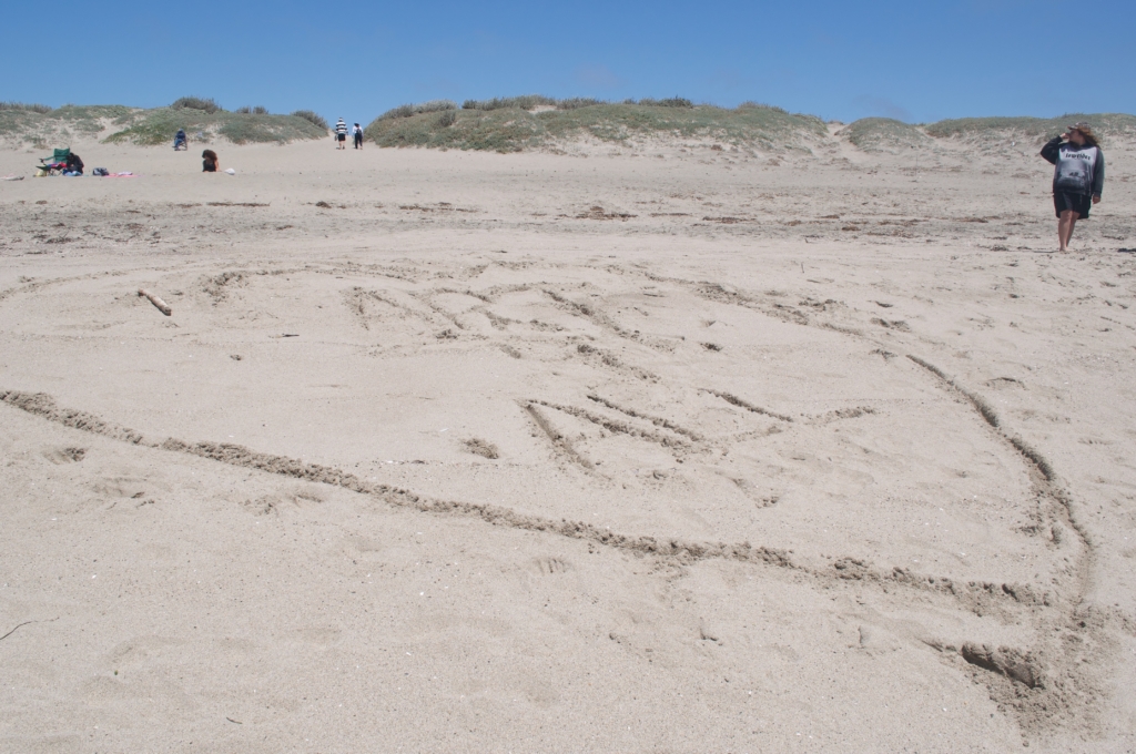 Art for All heart piece carved into the beach sand by Art for All students