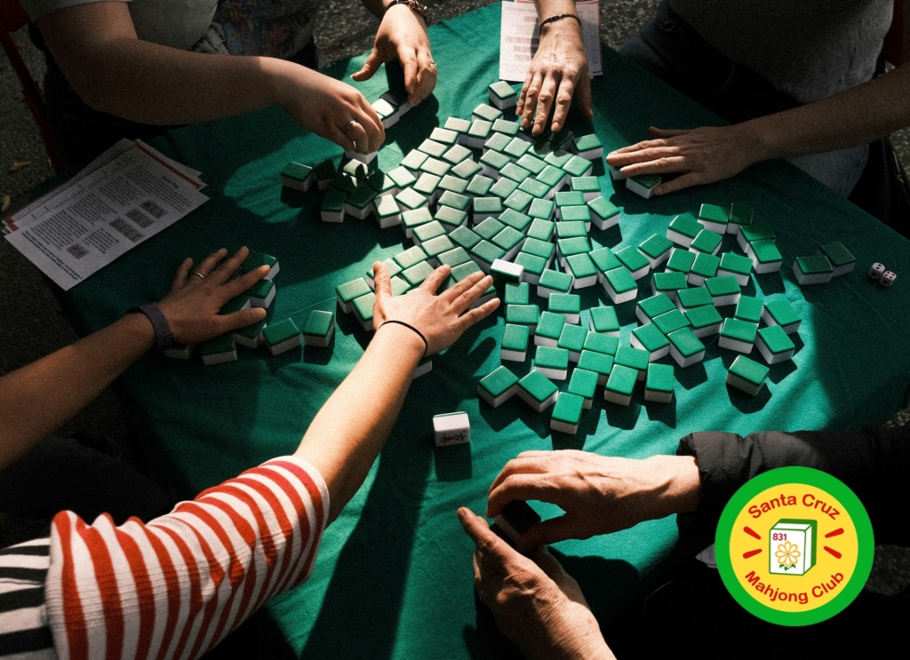 The hands of four people playing mahjong