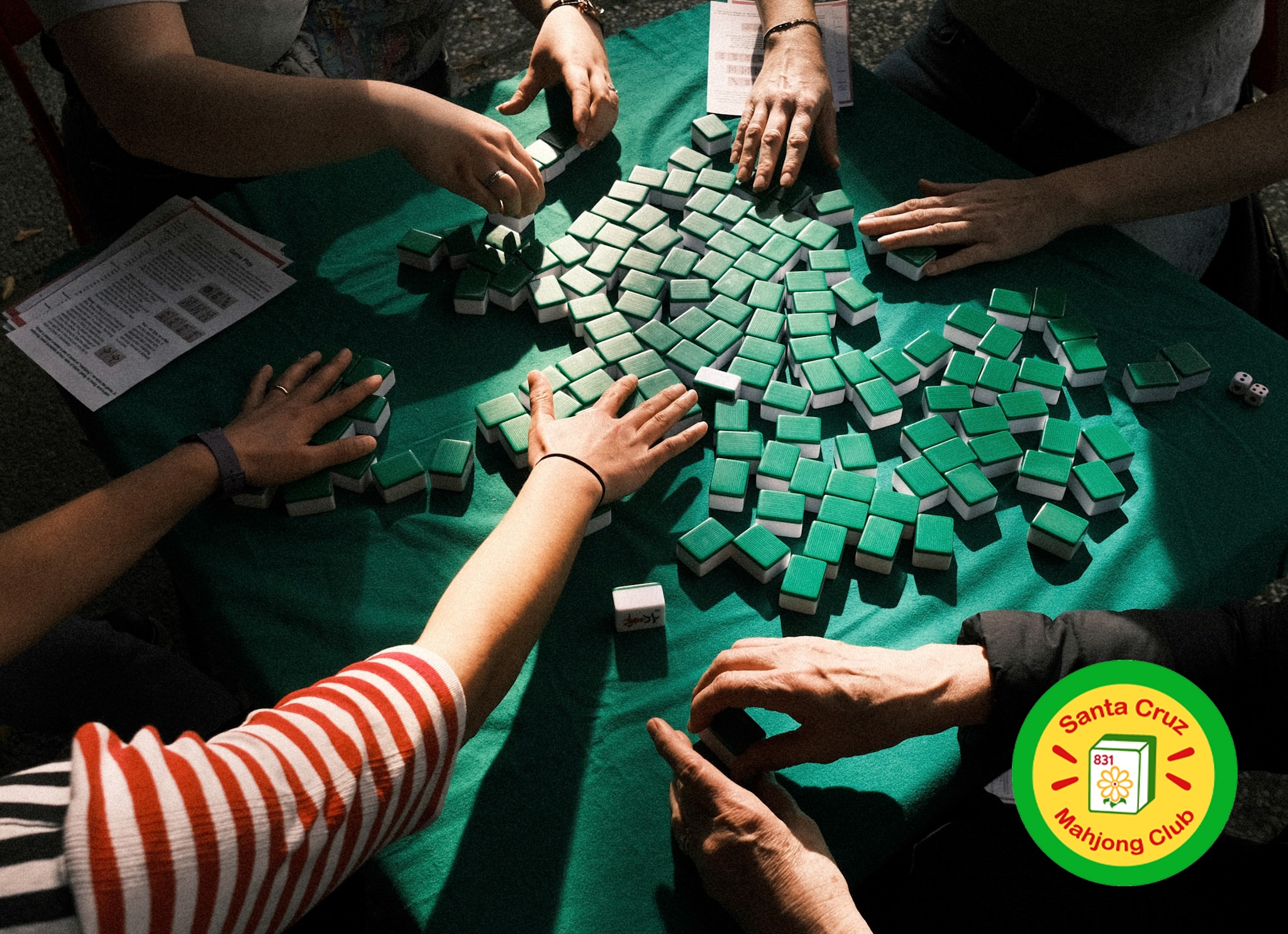 The hands of four people playing mahjong