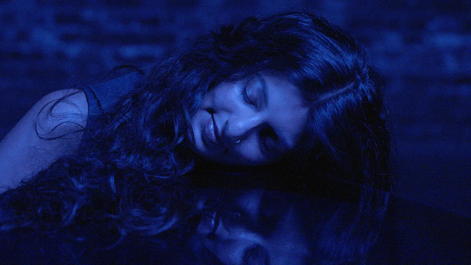 blue tinted image of woman lying down